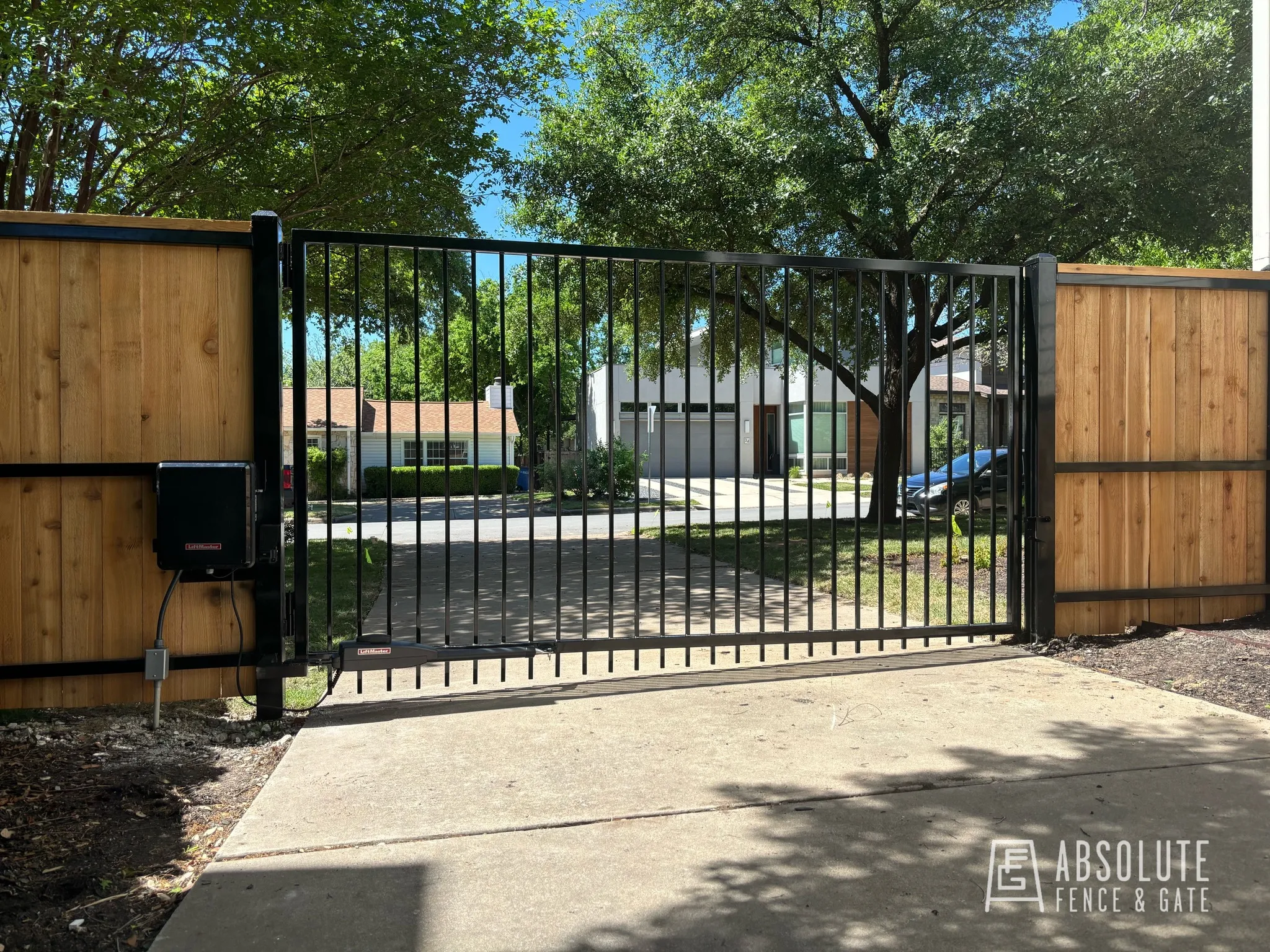 Custom steel driveway gate with operator by Absolute Fence & Gate in Austin