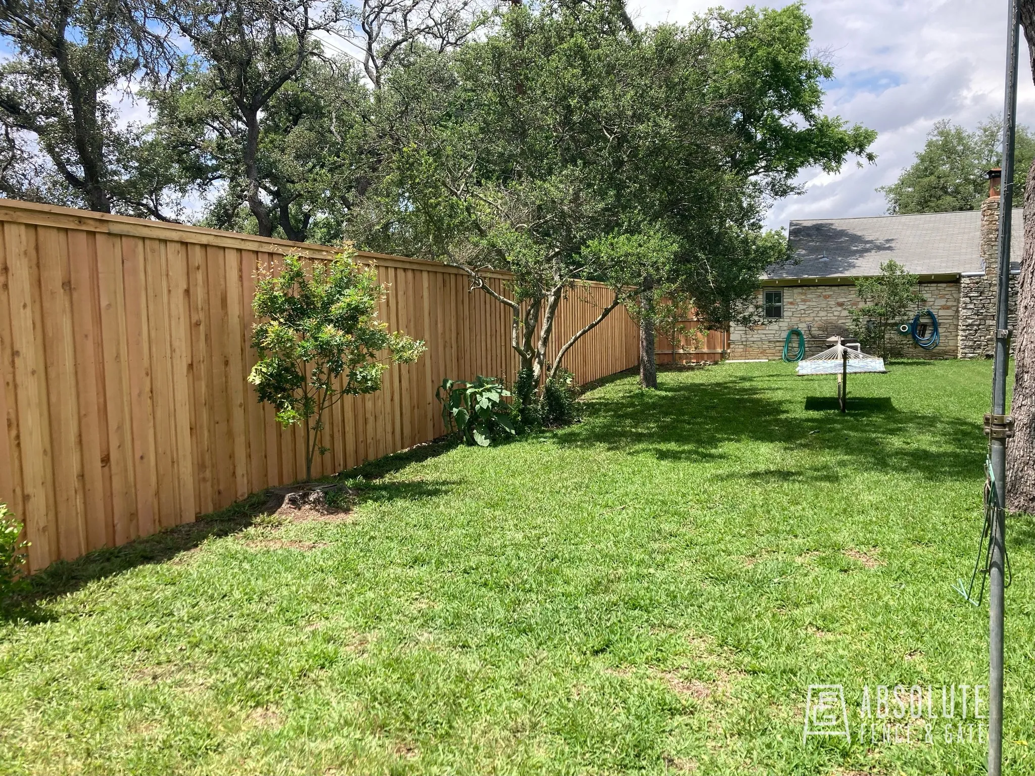 Cedar fence installation in a lush Austin yard