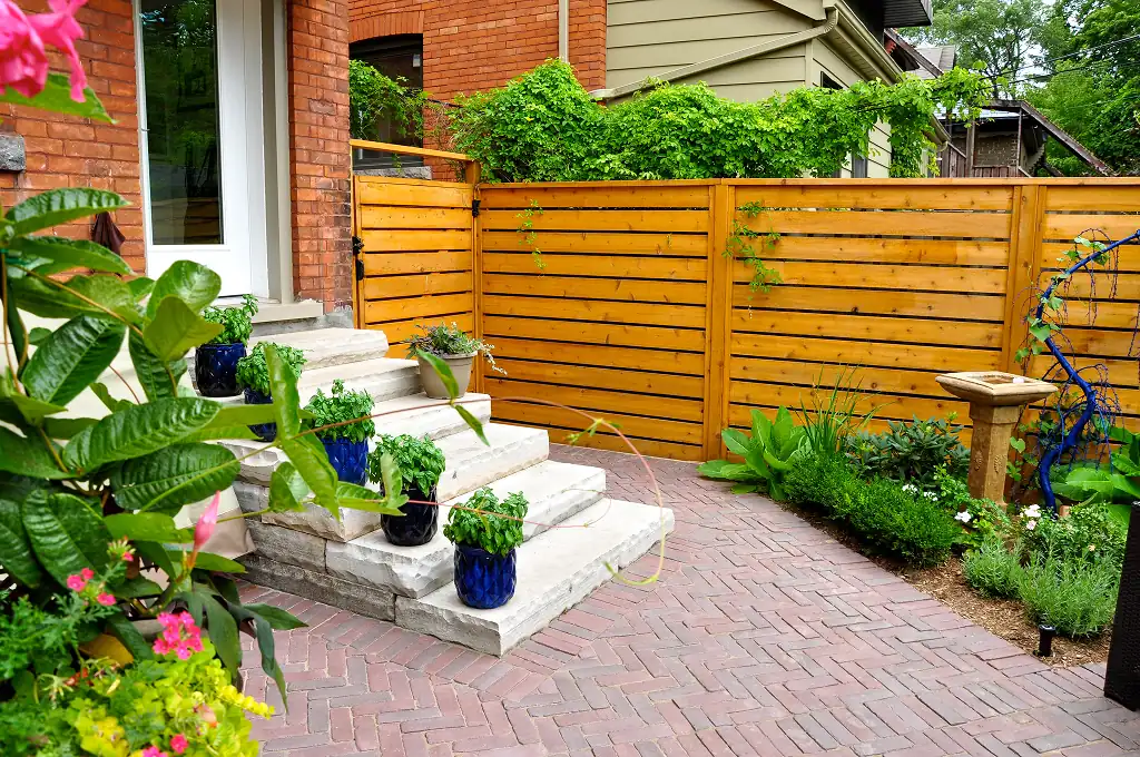 Horizontal wood fence and gate in a brick courtyard