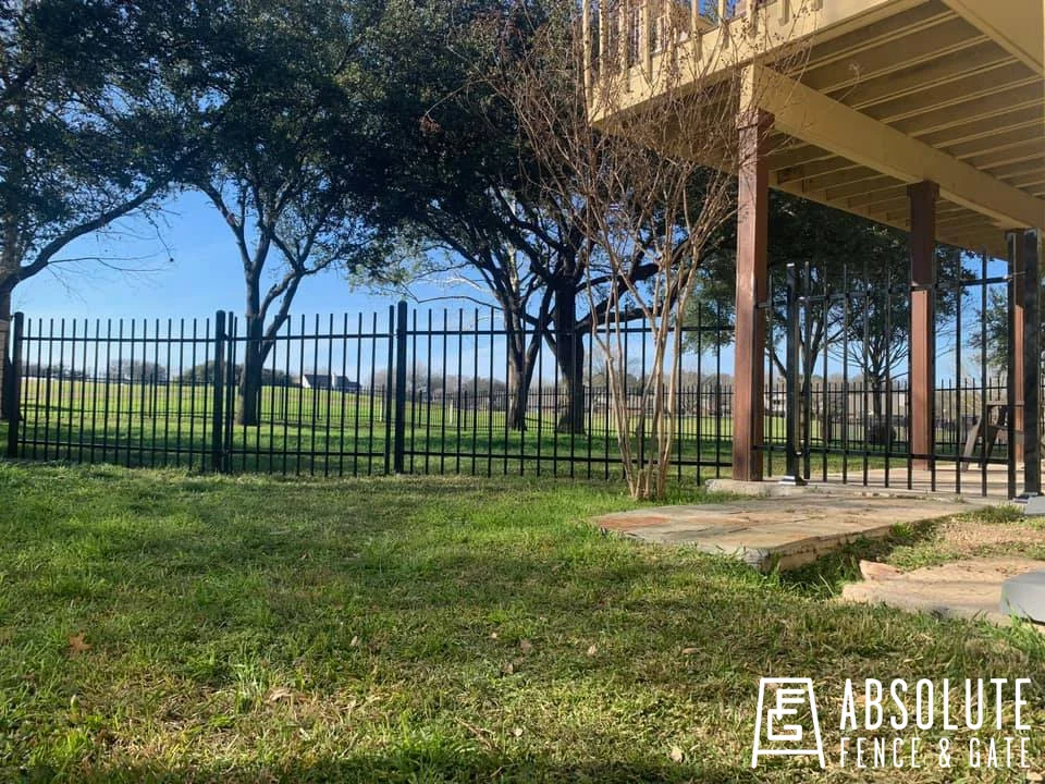 Black ornamental steel fence around an Austin backyard below a deck